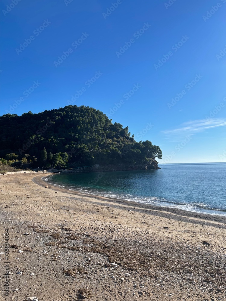 Pebble beach on Montenegrin coast with clear water and by summer day. Pebble beach on Montenegrin coast with clear water and by summer day.