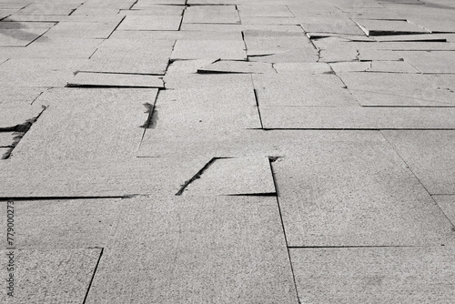 Cracked granite paving slabs. Selective focus.