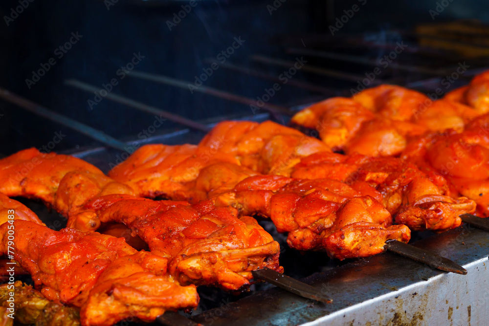 A row of middle east food of chicken satay skewers being grilled on a grill.