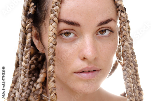 A portrait of a young woman with dreadlocks looking into the camera
