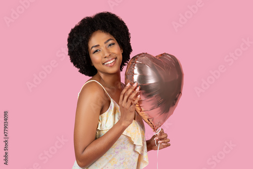 African American woman hugging a heart-shaped balloon lovingly photo