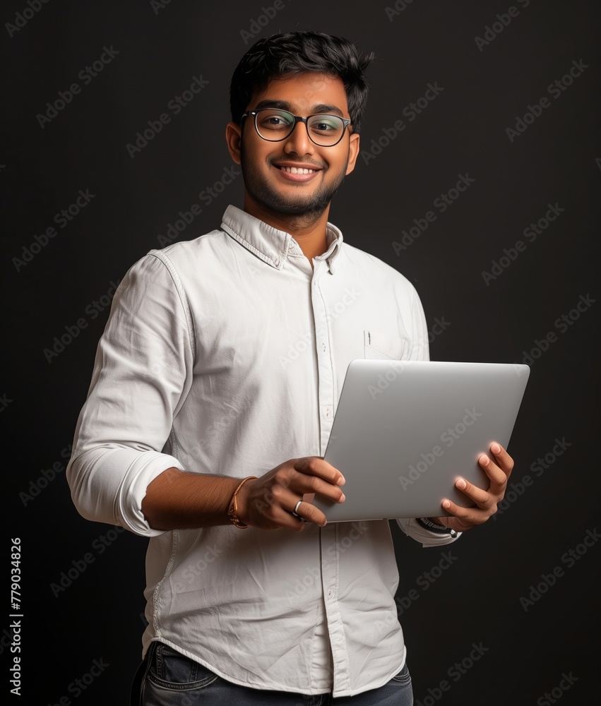 Young Entrepreneur with Laptop on Dark Background Young Entrepreneur with Laptop on Dark Background