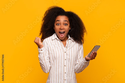 Woman pumped up looking at smartphone screen photo