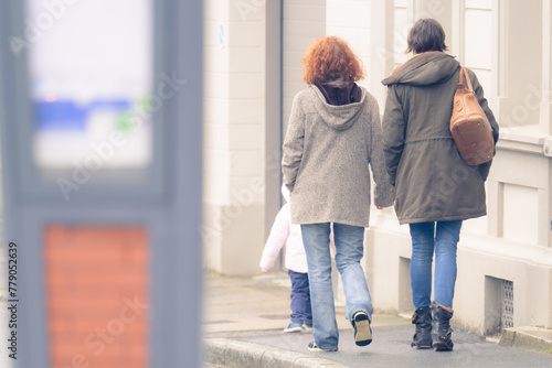 Couple de deux femmes vues de dos marchant dans la rue