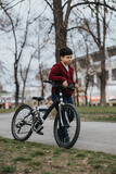 Joyful young boy riding his bicycle outdoors in the park, representing childhood, activity, and happiness.