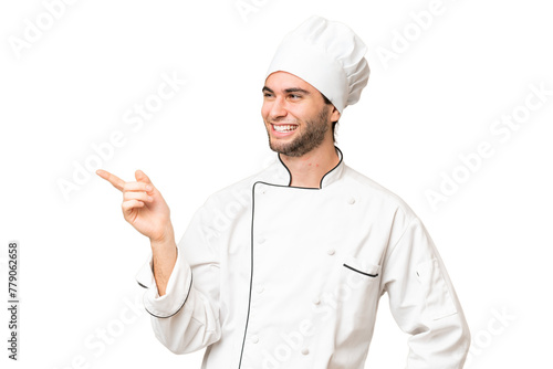 Young handsome chef man over isolated background pointing finger to the side and presenting a product photo