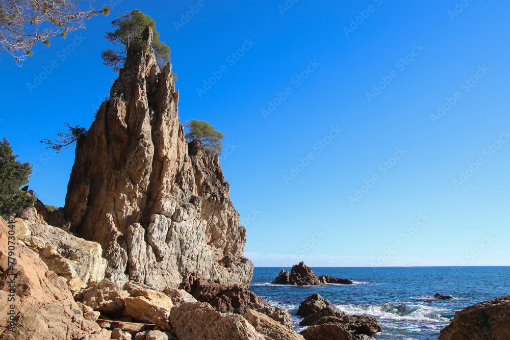 Una roca puntiaguda en una cala en la costa mediterránea