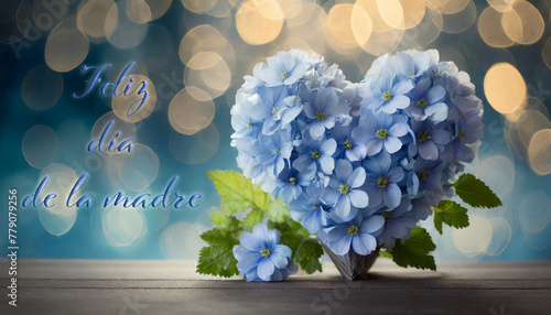 tarjeta o pancarta para desear un feliz Día de la Madre en azul con al lado un corazón hecho de flores azules y follaje verde sobre un fondo azul degradado con círculos en efecto bokeh