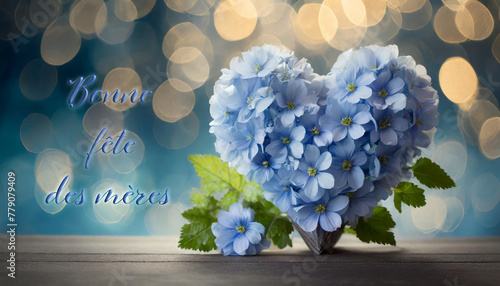 carte ou bandeau pour souhaiter une bonne fête des mères en bleu avec à côté un coeur formé de fleurs bleues  et du feuillage vert sur un fond bleu en dégradé avec des ronds en effet bokeh