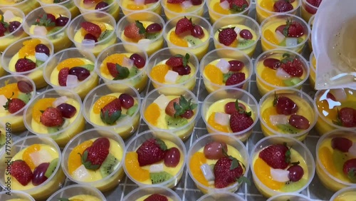 Home industry catering makes healthy mango milk pudding. Puddings are made from mango juice and milk. Topping: vanilla jelly, strawberry, grape, kiwi, mandarin orange, and nata de coco (coconut gel). photo