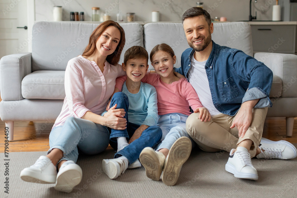 Happy family sitting together on floor at home Happy family sitting together on floor at home