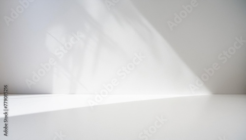 Base o mesa de color  blanco y una pared lisa blanca y sombras, detalle de una habitación vacía