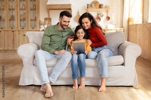 Happy family with tablet on a couch