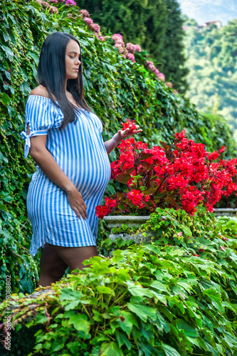 Gorgeous pregnant South American girl, wearing a long striped shirt