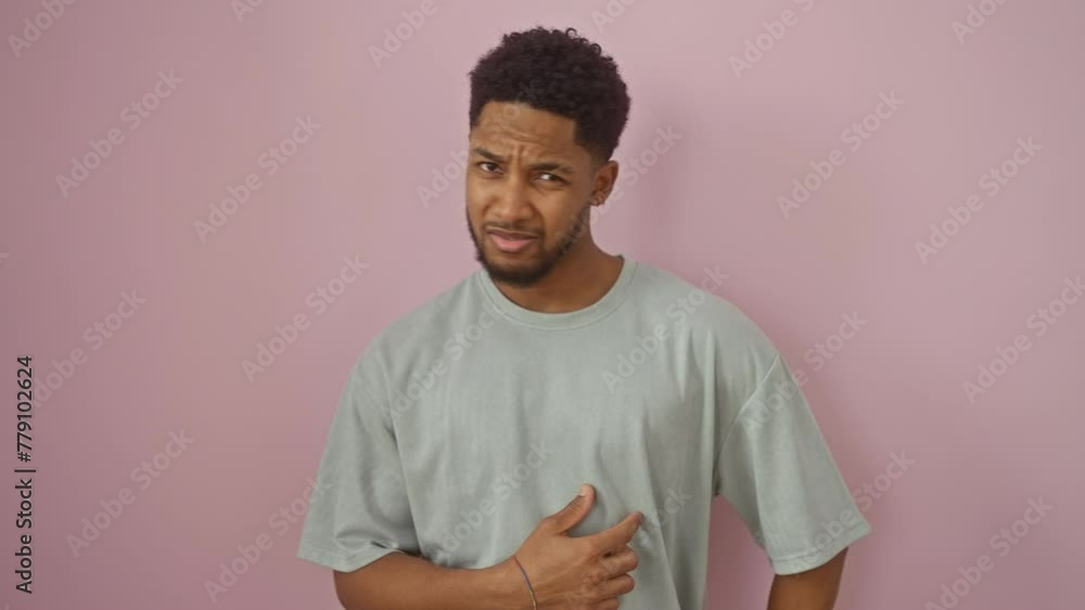 Skeptical african american man wearing t-shirt, stunned expression on his face, sarcastically shocked with mouth open, standing isolated on a pink background Skeptical african american man wearing t-shirt, stunned expression on his face, sarcastically shocked with mouth open, standing isolated on a pink background