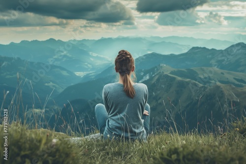 A woman enjoys solitude with nature, sitting on the grass in the mountains, immersed in the world of tranquility and beauty of the surrounding landscape