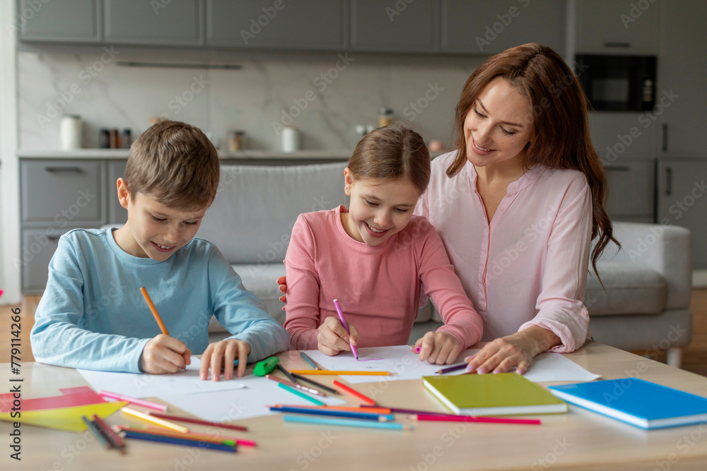 Mother and two kids drawing together at home