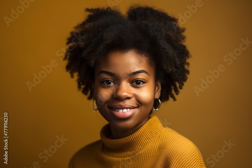 A woman with curly hair is smiling and wearing a yellow sweater © Juan Hernandez