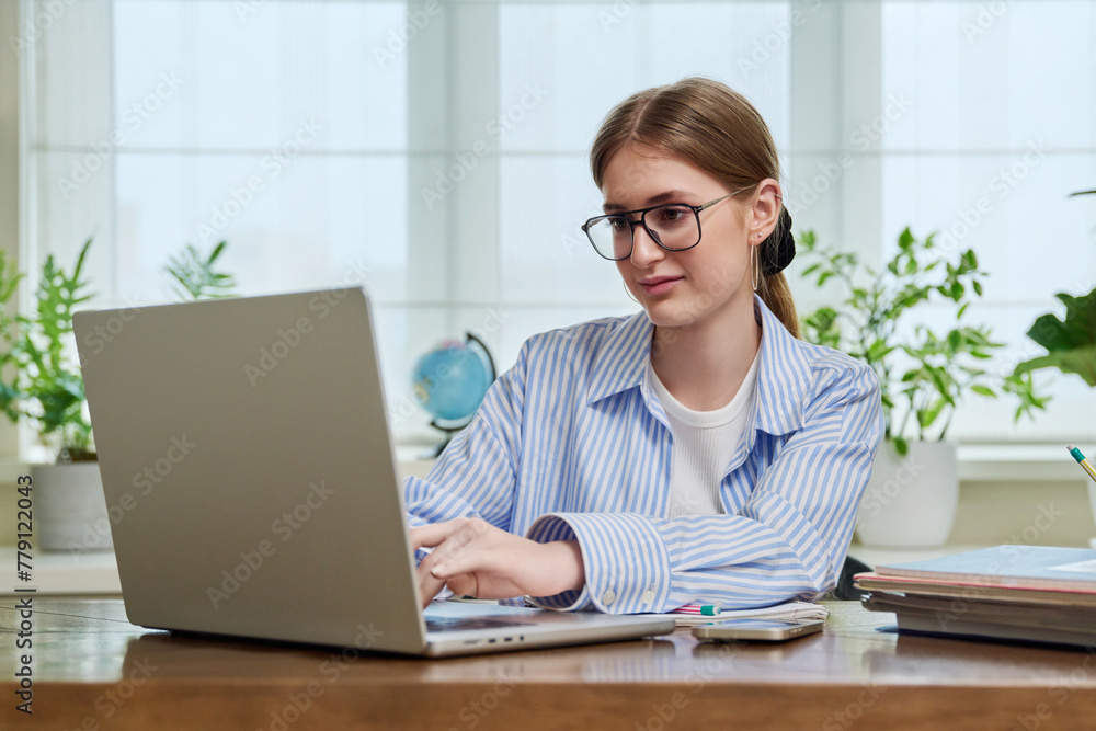 Young smiling female typing on laptop computer at home Young smiling female typing on laptop computer at home