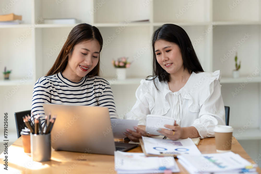 Two cheerful businesswomen brainstorming and sharing ideas in a collaborative workspace, with a laptop and coffee on the table. Two cheerful businesswomen brainstorming and sharing ideas in a collaborative workspace, with a laptop and coffee on the table.