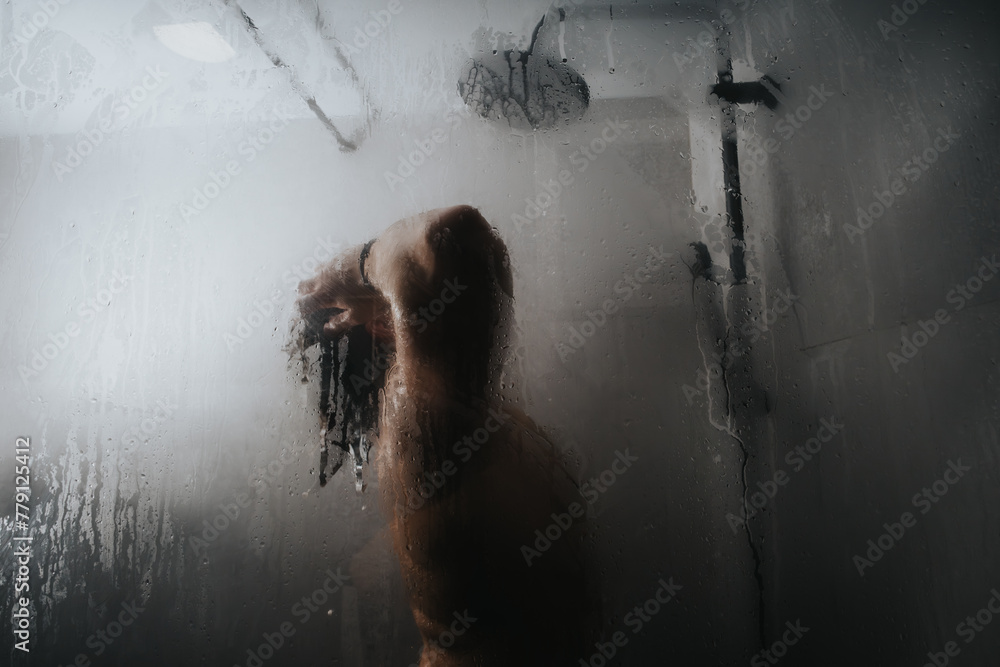 Obraz premium A contemplative mood emanates from the silhouette of a lone person, obscured by the mist of a hot shower.