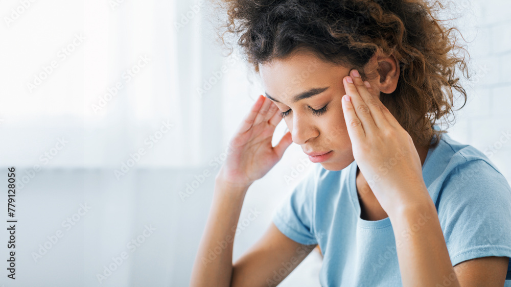 African-american woman suffering from headache at home African-american woman suffering from headache at home