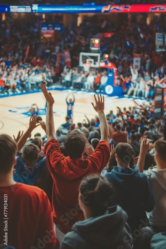 Basketball game from the perspective of the crowd, with fans cheering, waving banners, and showing support for their team photo