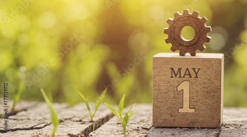 Wooden calendar block with metallic gear, green sprout and May 1 date as symbol of International Workers', Labour, Labor Day celebration photo