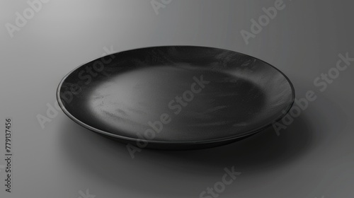 A simple black plate on a wooden table. Suitable for food and kitchen concepts