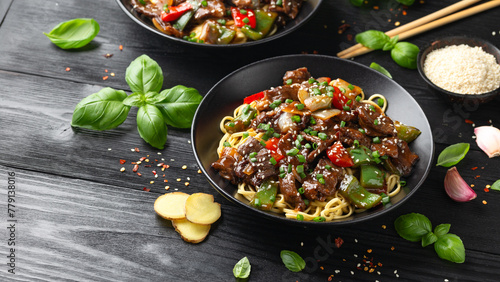 Stir fried beef in black bean sauce with vegetables and noodles. Take away food photo
