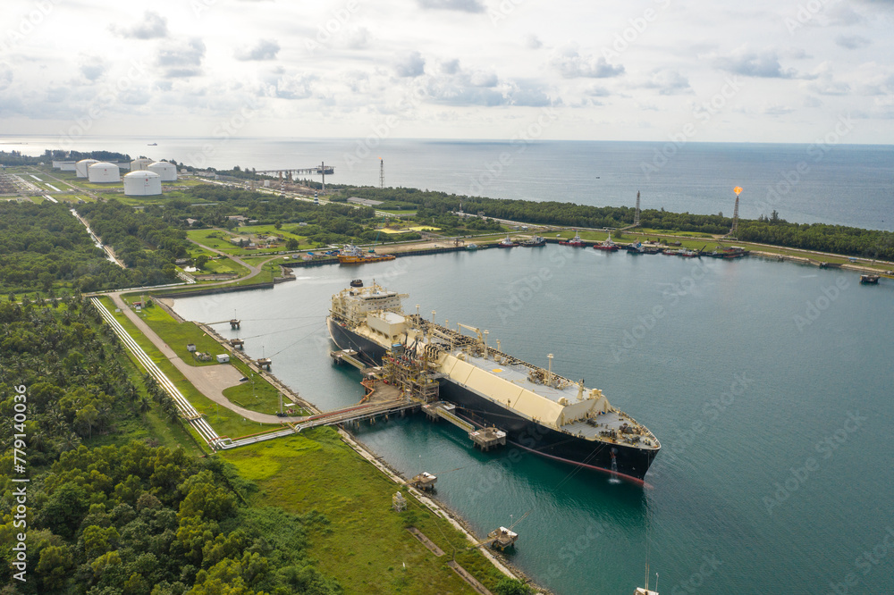 Aerial view of a large ship docked at a gas industrial factory area