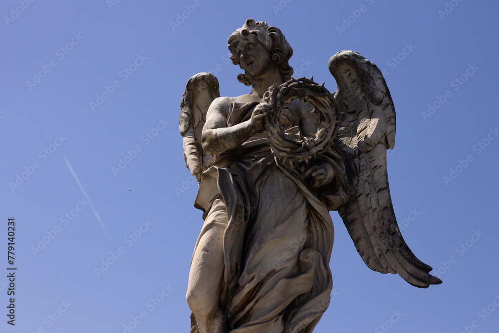 Fototapeta premium Monument of a Roman Angel during a sunny and warm day in summer in the city of Rome, Italy near the Saint Angelo Castle.