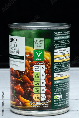  Tesco branded Lentil and vegetable bolognese in a tin can that is recyclable displaying graphics Kcal icons general information Vagan Icon relevant to the image and product.