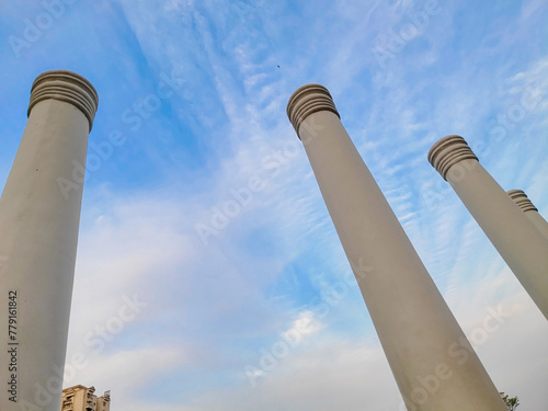 An architectural close-up of pillars touching  the blue sky. Touching the sky.