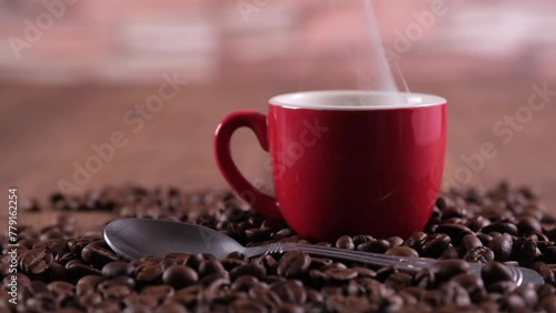 Tazzina tra i chicchi di caffè primo piano di tazzina rossa con caffè caldo photo