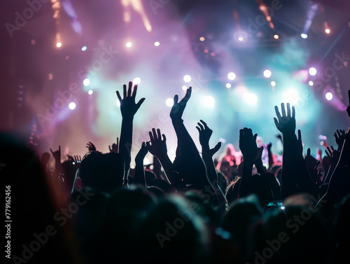 silhouettes of concert crowd in front of bright stage lights.