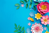 top view of bright colorful paper cut flowers with green leaves on blue background.