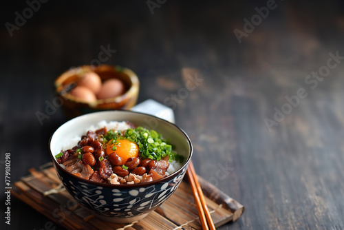 sekihan ou osekihan, plat traditionnel japonais, riz gluant mochigome, cuit à la vapeur avec des haricots rouge azuki, de la cebette, un oeuf poché dans un bol avec des baguettes sur une table en bois photo