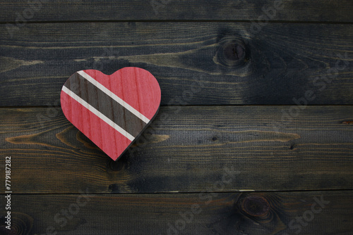 wooden heart with national flag of trinidad and tobago on the wooden background.