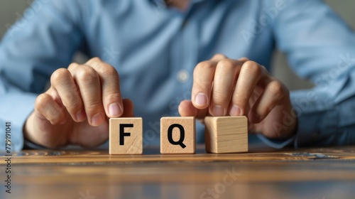Businessman puts wooden blocks with the word FAQ (frequently asked questions). Collection of frequently asked questions on any topic and answers to them. photo