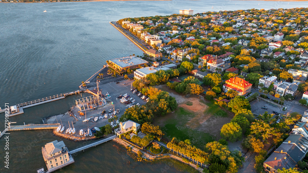 Obraz premium Golden sunrise light bathes downtown Charleston, South Carolina, with historic buildings and streets visible from an aerial view.