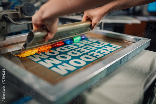 Bilde på lerret Graphic worker's hands pressing ink with squeegee and screen printing
