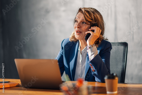 Female executive having phone call with important clients at office.