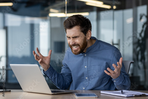 Frustrated businessman experiencing computer problems at work