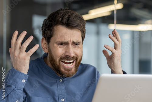 Frustrated man experiencing computer problems at work