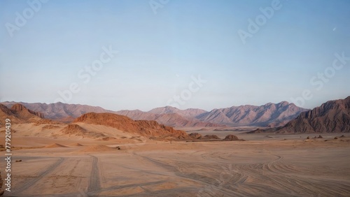 Mountains in the desert at dawn. Sandy landscape. Sunrise. Footprints on the sand. Beautiful view.