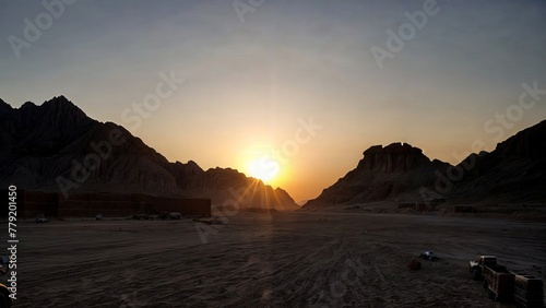 Rays of dawn over the mountains in the desert. Traces in the sand. Beautiful morning landscape.