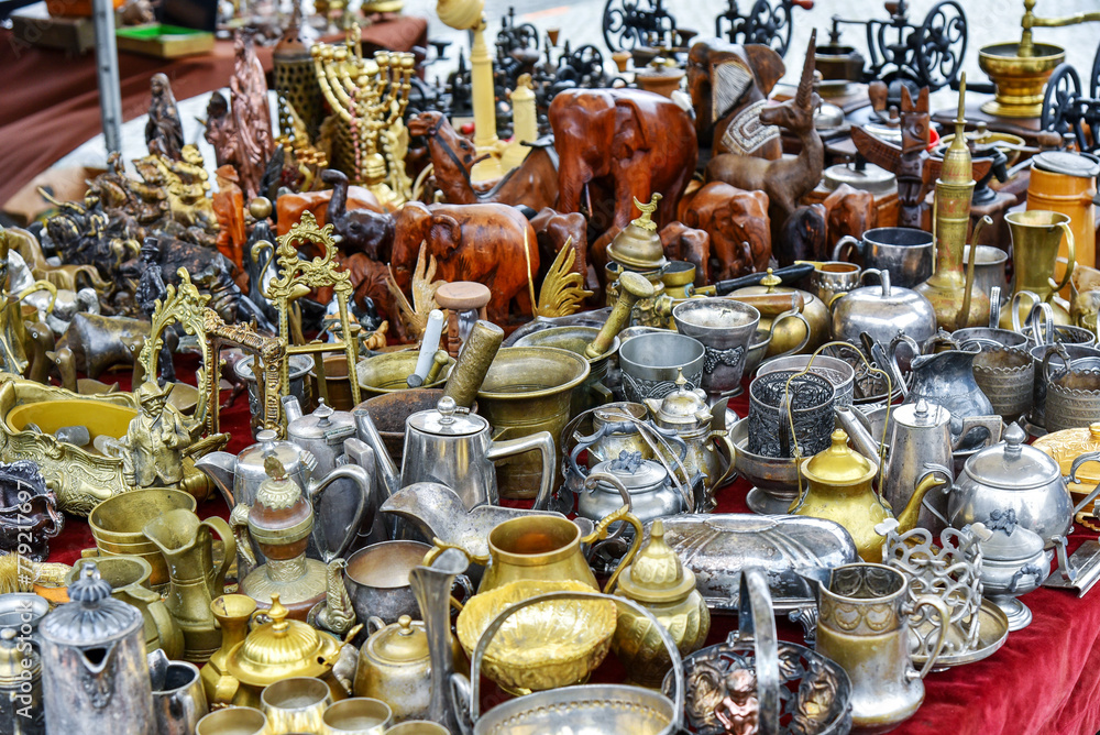 Set of silver, brass and copper utensils: jugs, teapots, bowls on flea market
