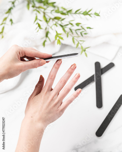 Woman filing her nails over trendy and modern bathroom counter