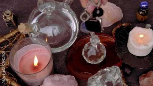female hand holding and using glass ball crystal ball, pendulum swings over astrologer's table, Harmony with meditation, self-discovery, Spiritual Energy and Balance, divination and fortune-telling photo